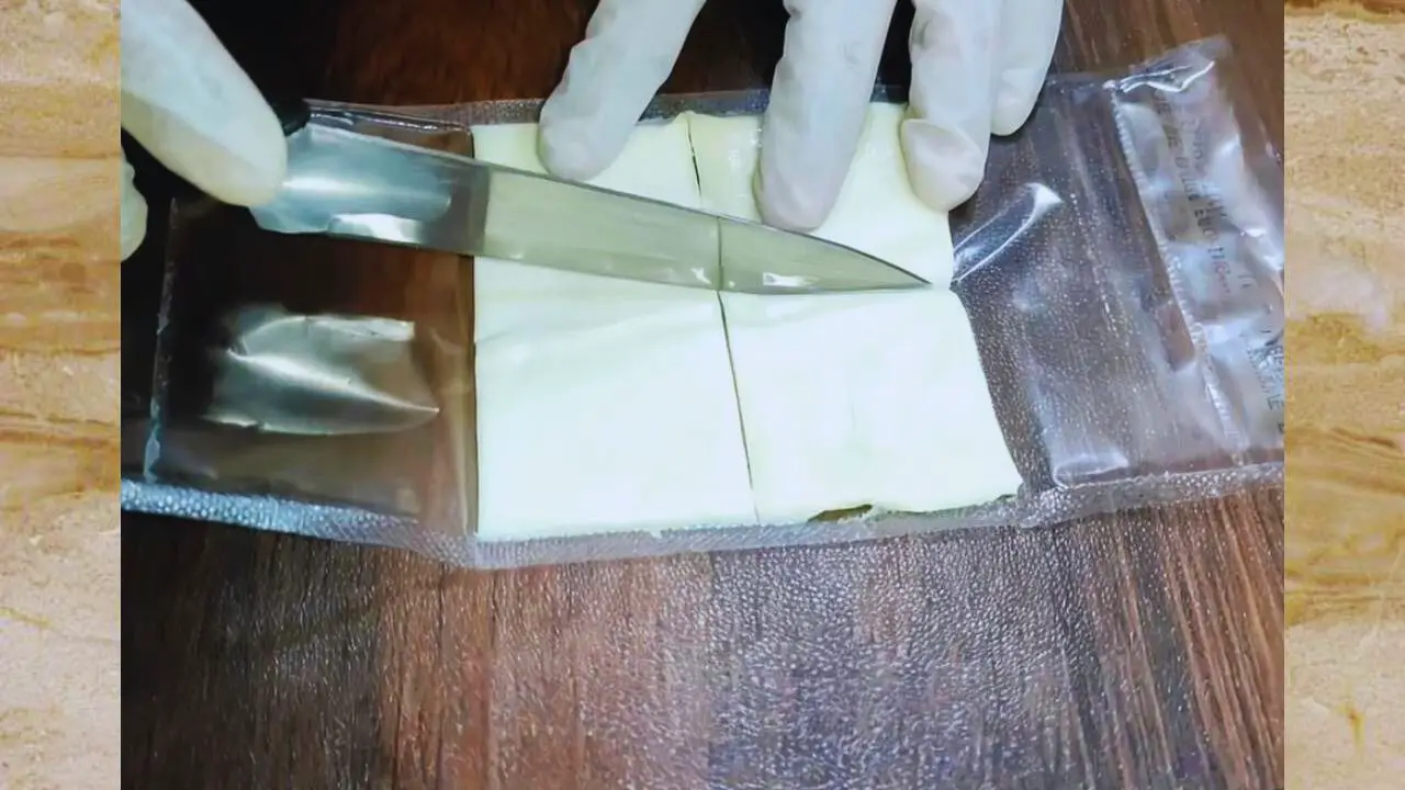 Cutting cheese slice into four pieces 