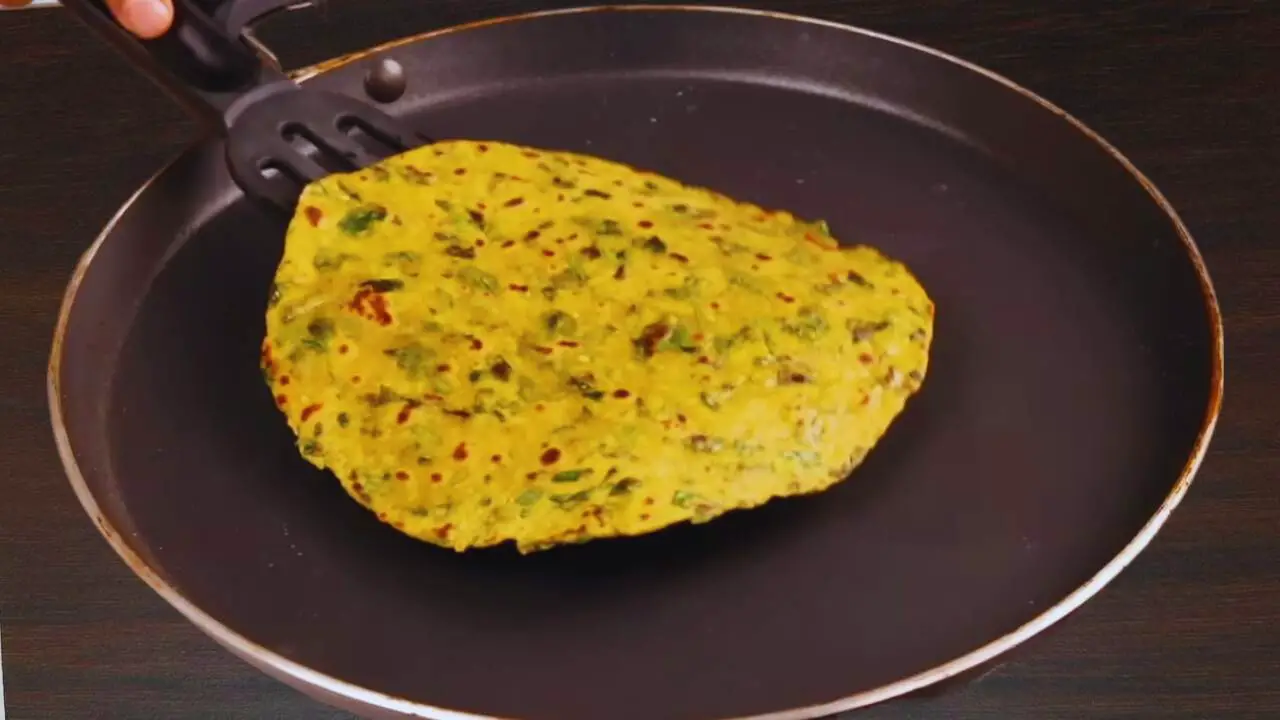 Removing fried Methi Paratha 
