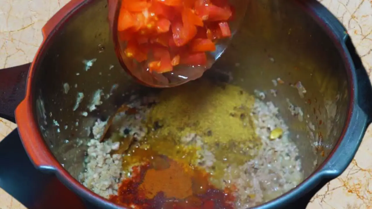 Adding powdered spices and tomatoes 