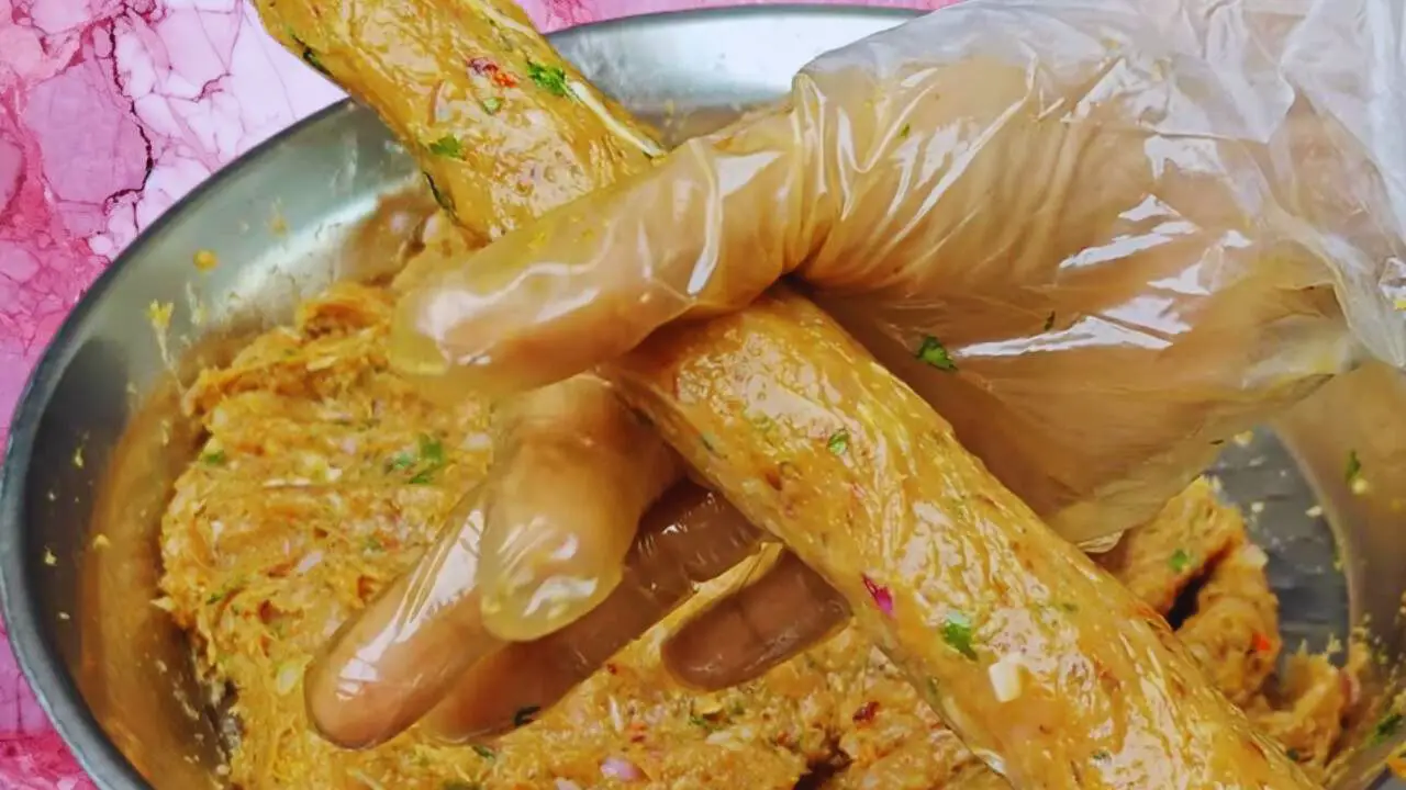 Putting chicken keema mixture on skewers 