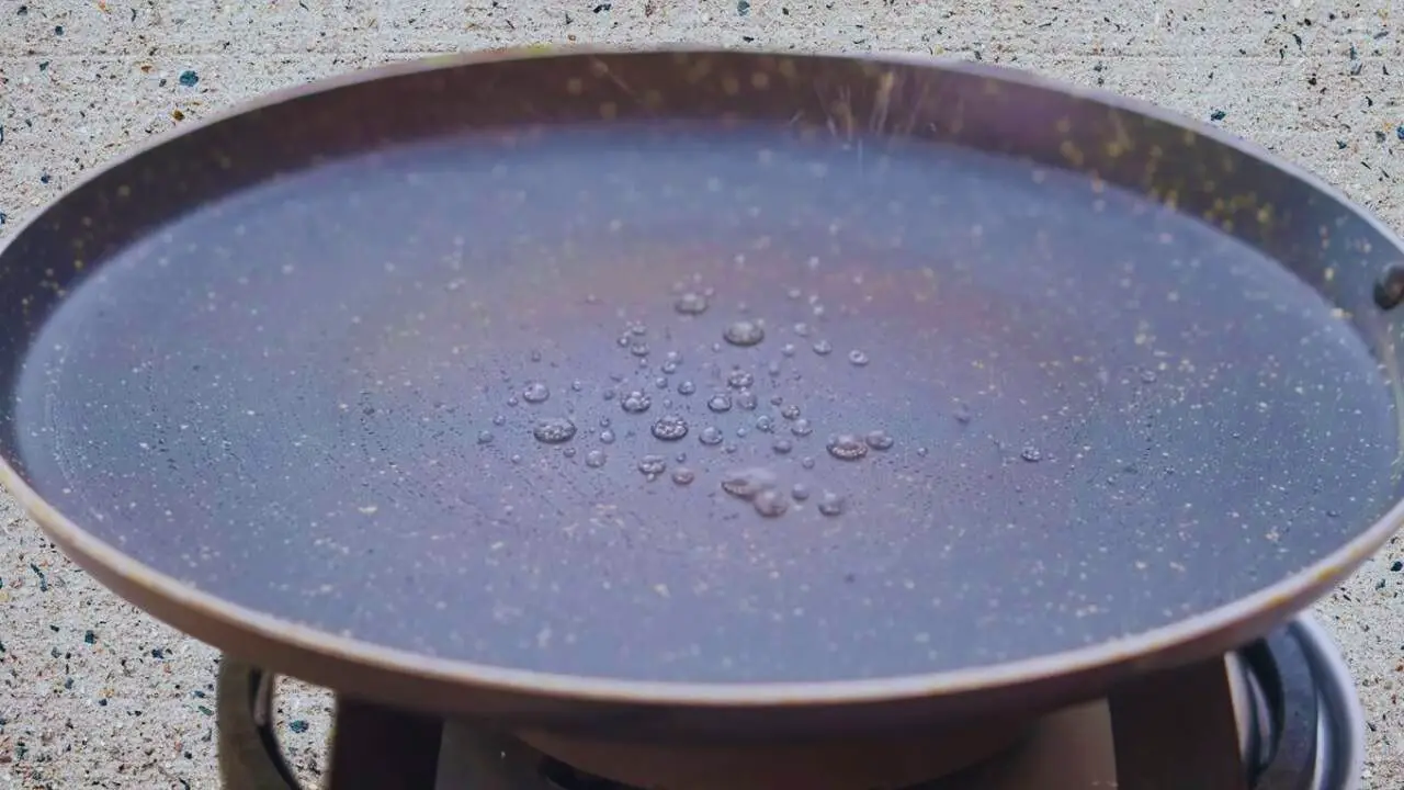 Sprinkling water on tawa